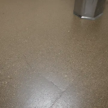 Floor mat near service entrance in Subway transfer station concourse. The area is being cleared for nightly lockdown. Wet edge of a rubber mat