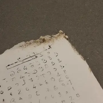 Overdue maintenance log sheet in Subway station administrative office. An employee is meticulously rereading a section of the log that details required safety checks. Yellowing...