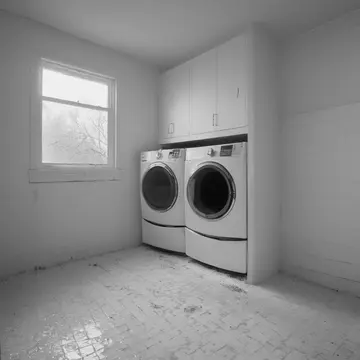 Stack of mismatched linens in Laundry room corner. The laundry routine is being completed after closing hours. Damp detergent residue on tile
