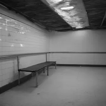 Unsecured service bench in Subway transfer mezzanine. The space is settling into its late-night quiet, requiring final checks. Wet tile sheen