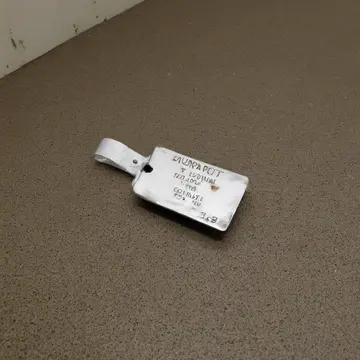 Unsorted luggage tag stack in Airport baggage claim carousel. The tags are stacked neatly on a low, chipped metal table. scuffed linoleum floor