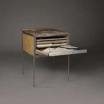 Card Index Card Cabinet in Archival Records Department Annex. A junior clerk is filing documents late after hours. Dust on the brass finger pulls