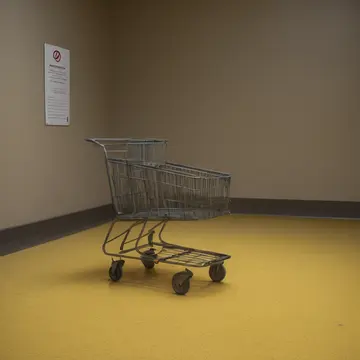 Seating arrangement and signage in Municipal lobby near service elevator. Inventory check during late evening cleanup. Yellowed laminated directional sign