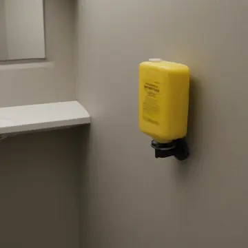 Industrial soap dispenser in Staff restroom supply closet. The dispenser counts the number of times it has been refilled. Soap residue streaks