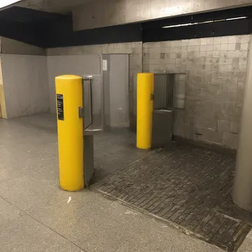 Turnstile mechanism in Subway platform corner. A single, stuck turnstile counts the number of attempts to pass. Yellow warning striping