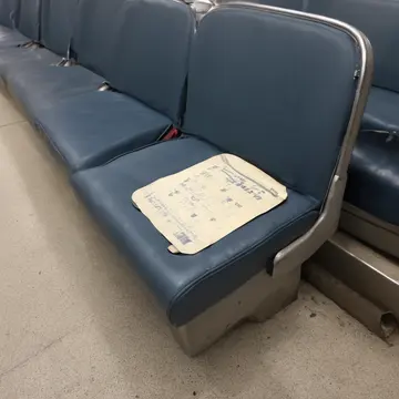 Transfer ticket stub in Bus seating area. A single ticket stub is placed on the seat cushion. Faded ink print