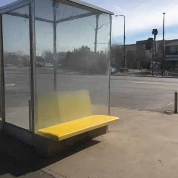 Receipt printer in Bus stop shelter corner. A ticket agent is slowly printing receipts. Scuffed yellow bench slats