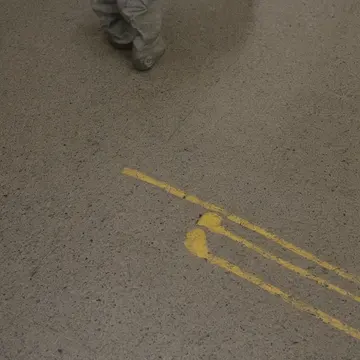Utility cart in Subway transfer lobby. People pausing near a section marked 'Temporary Access'. Wet grout lines