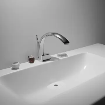 The soap dispenser pump in Kitchen sink basin. A single, unused sponge rests near the faucet. Wet porcelain edge