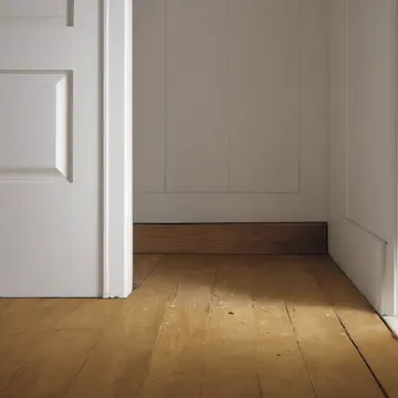 Rubber doorstop in Mudroom entryway. The door repeatedly opens inward, requiring repositioning of the stop. Yellowed wood grain