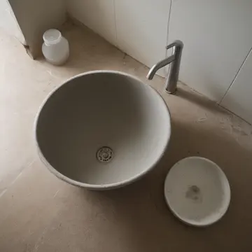 A stack of ceramic mixing bowls in Utility sink room. Waiting for the storm to pass through the building. Damp rubber matting on tile floor