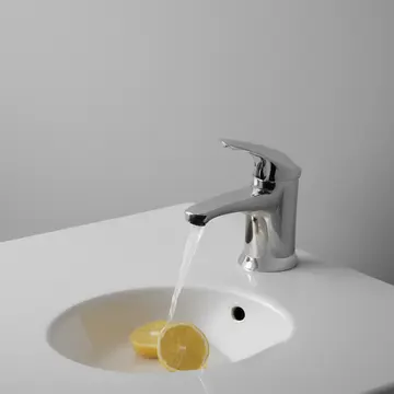 Industrial soap dispenser in Staff break room sink area. The dispenser counts the number of times it is refilled. Chrome faucet drip